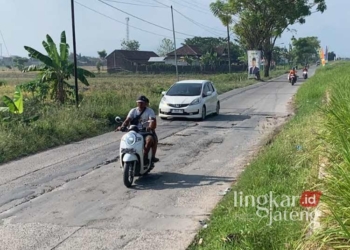 HATI-HATI: Sejumlah pengendara melewati jalan rusak di Desa Ngemplik, Kecamatan Karanganyar, Kabupaten Demak, pada Minggu, 4 Agustus 2024. (M. Burhanuddin Aslam/Lingkarjateng.id)