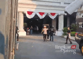 Tampak seorang jurnalis pers mahasiswa sedang di seret aparat kepolisian untuk di amankan ke Gedung DPRD Kota Semarang pada Senin sore, 26 Agustus 2024. (Rizky Syahrul Al-Fath/Lingkarjateng.id)