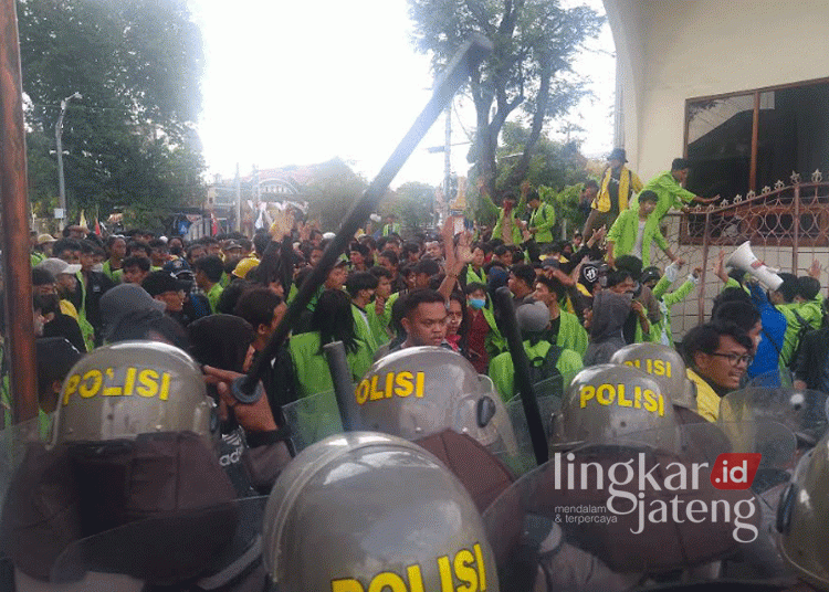 Tampak mahasiswa menjebol pagar besi mencoba ingin masuk ke Gedung DPRD Kota Semarang namun di hadang oleh aparat kepolisian dalam aksi demonstrasi pada Senin sore, 26 Agustus 2024. (Rizky Syahrul Al-Fath/Lingkarjateng.id)