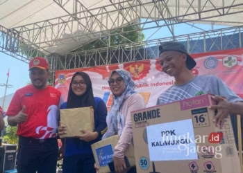 Camat Satria Agus Himawan (kiri) saat memberikan hadiah pada rangkaian perayaan HUT ke-79 RI di Kecamatan Kaliwungu, Kudus. (Dok. HMS/Lingkarjateng.id)