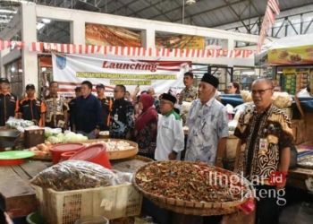 KHIDMAT : Sejumlah pedagang bersama Ketua DPRD Kota Salatiga, Pj Wali Kota, dan para pejabat menyanyikan lagu Indonesia Raya di Pasar Raya 1 Salatiga pada Kamis, 1 Agustus 2024. (Dok. Prokompim Setda Salatiga/Lingkarajateng.id)