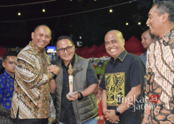 Dandim 0718/Pati Letkol Inf Jon Young Saragi (berkaca mata) saat menerima piala juara 1 menembak pistol antar-Dansat dalam acara syukuran puncak peringatan HUT ke-63 Korem 073/Makutarama di halaman Makorem Salatiga pada Jumat malam, 6 September 2024. (Dok. HMS/Lingkarjateng.id)