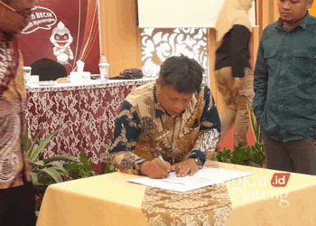 Ketua KPU Grobogan, Agung Sutopo, saat menandatangani berita acara dalam rapat pleno terbuka penetapan daftar pemilih tetap (DPT) untuk Pilkada 2024 yang digelar di Hotel 21 Purwodadi pada Rabu, 18 September 2024. (Eko Wicaksono/Lingkarjateng.id)