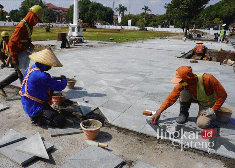 Sejumlah pekerja tengah memasang batu andesit untuk lantai jogging track dalam revitalisasi Alun-alun 1 Kabupaten Jepara pada Selasa, 10 September 2024. (Muhammad Aminudin/Lingkarjateng.id)