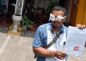 Anggota Panwaslu Desa Tambakromo, Muhammad Chundori, menunjukkan surat pengunduran diri sekaligus melakukan aksi menutup mata karena kecewa dengan kinerja Bawaslu Pati pada Selasa, 22 Oktober 2024. (Arif Febriyanto/Lingkarjateng.id)