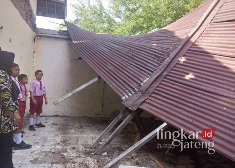 Guru dan sejumlah siswa SDN 3 Godan, Kecamatan Tawangharjo, Grobogan, saat berada di ruang kelas 6 yang atapnya ambrol akibat guyuran hujan deras, baru-baru ini. (Dok. Pribadi/Lingkarjateng.id)