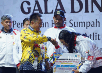 Pj. Wali Kota Salatiga, Yasip Khasani, bersalaman dengan salah satu atlet peraih medali di ajang PON saat menyerahkan bonus uang pembinaan pada Rabu malam, 30 Oktober 2024. (Dok. Diskominfo Salatiga/Lingkarjateng.id)