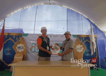 Kepala SMK Telkom Terpadu AKN Marzuqi, Winarno Suryo Edi Subroto (kiri), menunjukkan surat perjanjian kerja sama dengan salah satu perusahaan dalam kegiatan job fair yang diselenggarakan sekolah setempat yang berlokasi di Kecamatan Dukuhseti, Kabupaten Pati, pada Sabtu, 12 Oktober 2024. (Arif Febriyanto/Lingkarjateng.id)