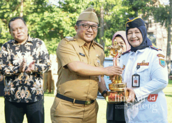 Pj. Wali Kota Salatiga, Yasip Khasani, saat memberikan piala penghargaan Wahana Tata Nugraha kepada Kepala Dishub Salatiga, Sri Satuti, dalam kegiatan apel luar biasa di Halaman Kantor Pemkot Salatiga, pada Senin, 7 Oktober 2024. (Dok. Prokompim Setda Salatiga/Lingkarjateng.id)