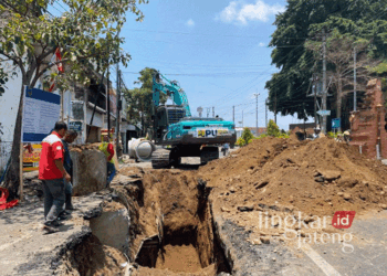 Sejumlah pekerja dan alat berat tengah menggarap proyek pembangunan drainase di Jalan Sunan Kudus, Kecamatan/Kabupaten Kudus, pada Senin, 28 Oktober 2024. (Mohammad Fahtur Rohman/Lingkarjateng.id)