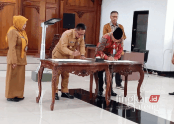 Pj. Wali Kota Salatiga, Yasip Khasani (dua dari kiri), menandatangani Naskah Penandatangan Hibah Daerah (NPHD) lampu penerangan jalan umum sebanyak 1.472 unit di Ruang Kaloka Kantor Setda Kota Salatiga pada Senin, 21 Oktober 2024. (Angga Rosa/Lingkarjateng.id)