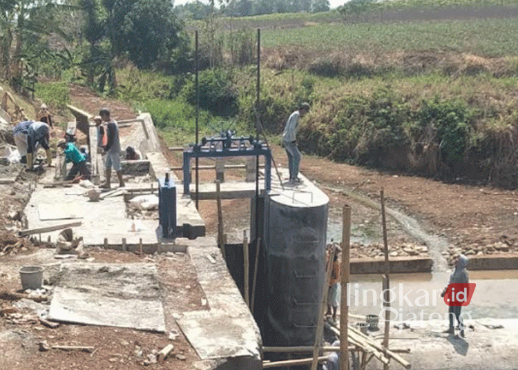 Sejumlah pekerja tengah menggarap proyek pembangunan saluran irigasi di Desa Purworejo, Kecamatan Margoyoso, Kabupaten Pati, pada Rabu, 9 Oktober 2024. (Arif Febriyanto/Lingkarjateng.id)