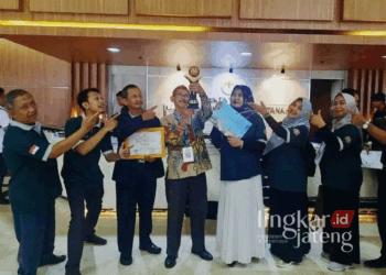 Kepala SMAN 1 Kota Pekalongan, Abdur Rozak (berbaju batik), bangga menunjukkan trofi penghargaan Adiwiyata Mandiri 2024 yang diraih dalam acara penganugerahan di Gedung Manggala Wanabakti, Jakarta, pada Rabu, 2 Oktober 2024. (Dok. Kominfo Kota Pekalongan/Lingkarjateng.id)