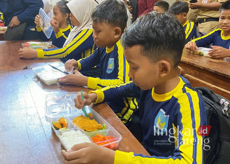 Para siswa SDN Gisikdrono 02, Semarang, Jawa Tengah, menyantap makanan yang dihidangkan. (Rizky Syahrul Al-Fath/Lingkarjateng.id)