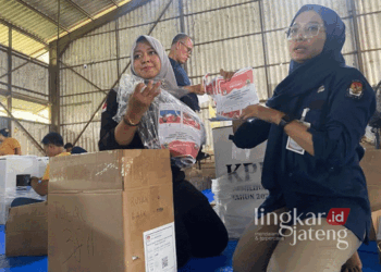 Petugas KPU Kudus Arika (kanan) dan Petugas Bawaslu Kudus Septyandra (kiri) saat menunjukkan suarat suara Pilkada yang rusak. (Mohammad Fahtur Rohman/Lingkarjateng.id)