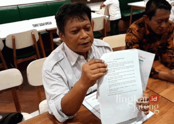 Ketua KPU Grobogan Agung Sutopo menunjukkan aturan pelaksanaan debat publik Pilkada pada Senin sore, 11 November 2024. (Eko Wicaksono/Lingkarjateng.id)