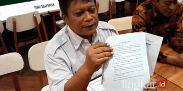 Ketua KPU Grobogan Agung Sutopo menunjukkan aturan pelaksanaan debat publik Pilkada pada Senin sore, 11 November 2024. (Eko Wicaksono/Lingkarjateng.id)