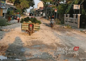 Sejumlah pengendara motor melintasi Jalan Sukolilo-Prawoto di Kabupaten Pati yang bertahun-tahun belum mendapat perbaikan. (Arif Febriyanto/Lingkarjateng.id)