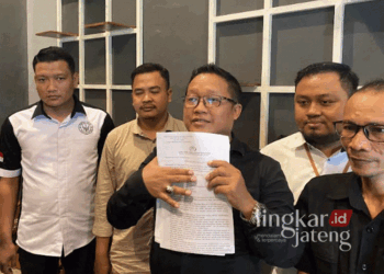 Kuasa Hukum Paslon Hartopo-Wahib, Yusuf Istanto, menunjukkan laporan terkait dugaan penganiayaan dan ancaman yang didapat oleh salah satu relawan. (Mohammad Fahtur Rohman/Lingkarjateng.id)