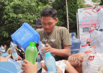 Seorang peternak sapi perah sedang membagi-bagikan susu dalam aksi protes aturan pembatasan serapan IPS di Kantor Kecamatan Getasan, Kabupaten Semarang, pada Minggu, 10 November 2024 lalu. (Hesty Imaniar/Lingkarjateng.id)