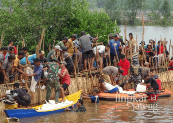 Warga bersama stakeholder bahu-membahu menutup tanggul Sungai Meduri-Bremi yang jebol menggunakan karung pasir di Kabupaten Pekalongan, Jawa Tengah. (Fahri Akbar/Lingkarjateng.id)