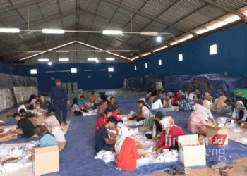 Puluhan orang tengah melipat dan menyortir surat suara Pilkada di Gudang KPU Jepara pada Kamis, 31 Oktober 2024. (Muhammad Aminudin/Lingkarjateng.id)