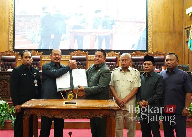 Ketua DPRD Pati Ali Badruddin (kanan) dan PJ Bupati Pati Sujarwanto Dwiatmoko (kiri) Menandatangani APBD tahun 2025 (Dok For Lingkar)