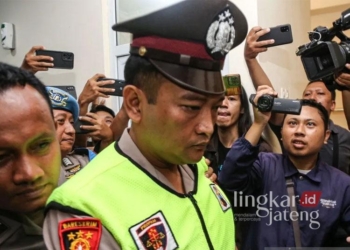 Aipda Robig Zainudin, pelaku penembakan siswa SMKN 4 Semarang, digiring petugas memasuki ruang sidang kode etik di Mapolda Jateng, Semarang, pada Senin, 9 Desember 2024. (Antara/Lingkarjateng.id)