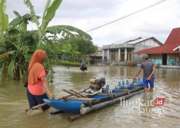 Warga terdampak banjir di Desa Karangrowo, Kecamatan Jakenan, Kabupaten Pati, terpaksa beraktivitas menggunakan prau pada musim penghujan 2023 lalu. (Setyo Nugroho/Lingkarjateng.id)