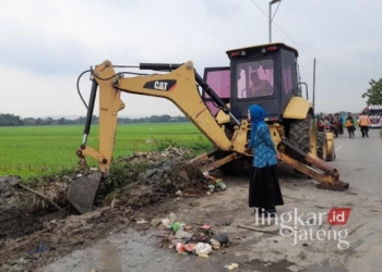 Istri Bupati Kendal, Wynne Frederica yang akrab disapa Chacha Frederica, saat turun langsung membersihkan tumpukan sampah di sepanjang jalan Desa Tambakrejo menuju Desa Bulugede, Kecamatan Patebon, pada Senin, 30 Desember 2024. (Arvian Maulana/Lingkarjateng.id)
