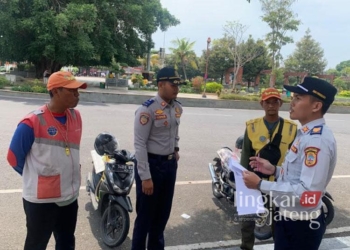 Anggota Dinas Perhubungan (Dishub) Kabupaten Pati tengah menyambangi juru parkir yang ada di Alun-alun Simpang Lima Pati baru-baru ini. (Setyo Nugroho/Lingkarjateng.id)