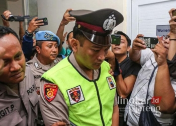 Aipda Robig Zainudin, terduga pelaku penembakan siswa SMKN 4 Semarang, digiring petugas memasuki ruang sidang kode etik di Mapolda Jateng, Semarang, pada Senin, 9 Desember 2024. (Antara/Lingkarjateng.id)