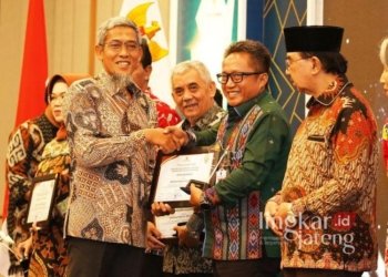 Pj Wali Kota Salatiga Yasip Khasani berjabat tangan dengan Sekda Provinsi Jateng Sumarno saat menerima piagam penghargaan anugerah pemeringkatan keterbukaan informasi badan publik di Semarang, Senin (9/12) malam. (Dok. Prokompim Setda Salatiga/Lingkarjateng.id) 