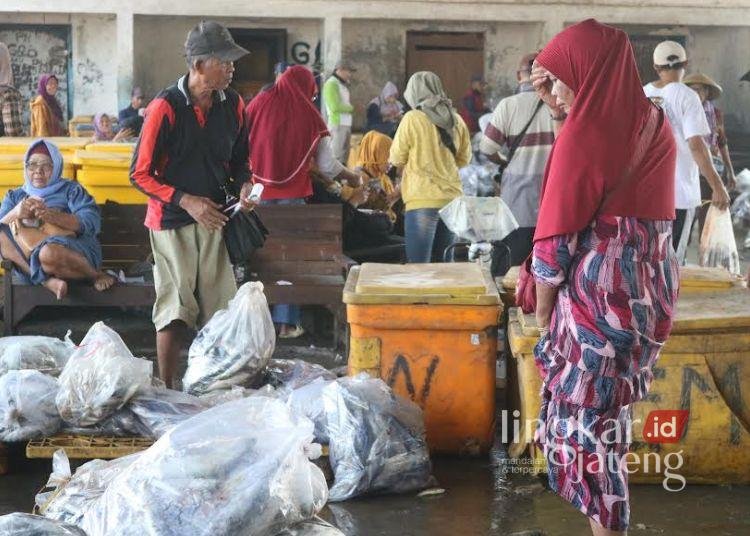 TRANSAKSI: Salah satu pembeli ikan di TPI Juwana Unit 1, Pati sedang memilih ikan tongkol dan kokot, Rabu, 15 Januari 2025. (Setyo Nugroho/Lingkar.news)