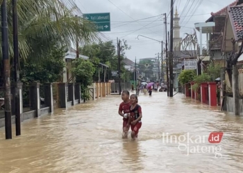 Warga Kecamatan Mejobo, Kabupaten Kudus, saat menerjang banjir yang melanda wilayah setempat ada Kamis, 30 Januari 2025. (Mohammad Fahtur Rohman/Lingkarjateng.id)