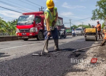 ILUSTRASI: Pekerja memperbaiki jalan yang rusak. (Antara/Lingkarjateng.id)