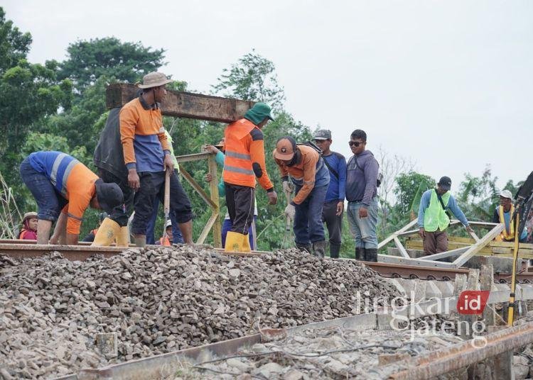 GOTONG ROYONG: Sejumlah pekerja gotong royong memperbaiki jalur kereta api yang terputus akibat banjir di titik Km 32+5/7 antara Stasiun Gubug - Stasiun Karangjati, Kabupaten Grobogan pada Rabu, 22 Januari 2025. (KAI/Lingkar.news)