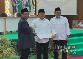 Ketua KPU Pati, Supriyanto, bersama Sudewo dan Risma Ardhi Chandra menunjukan berkas penetapan Calon Bupati dan Wakil Bupati Pati terpilih saat rapat pleno di Hotel Merdeka pada Kamis, 9 Januari 2025. (Setyo Nugroho/Lingkarjateng.id)
