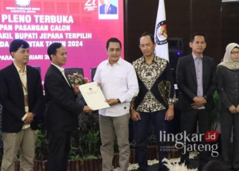 Ketua KPU Jepara, Ris Andi Kusuma, saat menyerahkan berita acara penetapan calon bupati-wakil bupati terpilih kepada tim pemenangan paslon Wiwit-Hajar di Hotel D'Season Jepara pada Kamis, 9 Januari 2025. (Muhammad Aminudin/Lingkarjateng.id)
