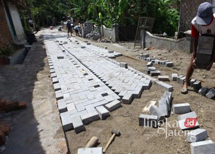 ILUSTRASI: Sejumlah warga menyelesaikan proses pemasangan paving block. (Antara/Lingkar.news)