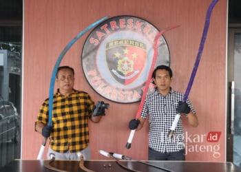 Anggota Satreskrim Polresta Pati memperlihatkan barang bukti senjata tajam dan pistol milik gangster yang sempat viral di media sosial beberapa hari lalu dalam konferensi pers di Mapolresta Pati pada Jumat, 17 Januari 2025. (Setyo Nugroho/Lingkarjateng.id)