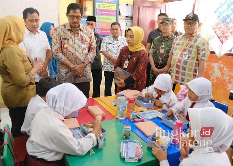 Pj. Gubernur Jawa Tengah, Nana Sudjana, didampingi Bupati Semarang, Ngesti Nugraha, saat meninjau langsung simulasi program makan bergizi gratis di SDN 02 Bedono, Kecamatan Jambu, Kabupaten Semarang, belum lama ini. (Dok. Hesty Imaniar/Lingkarjateng.id)