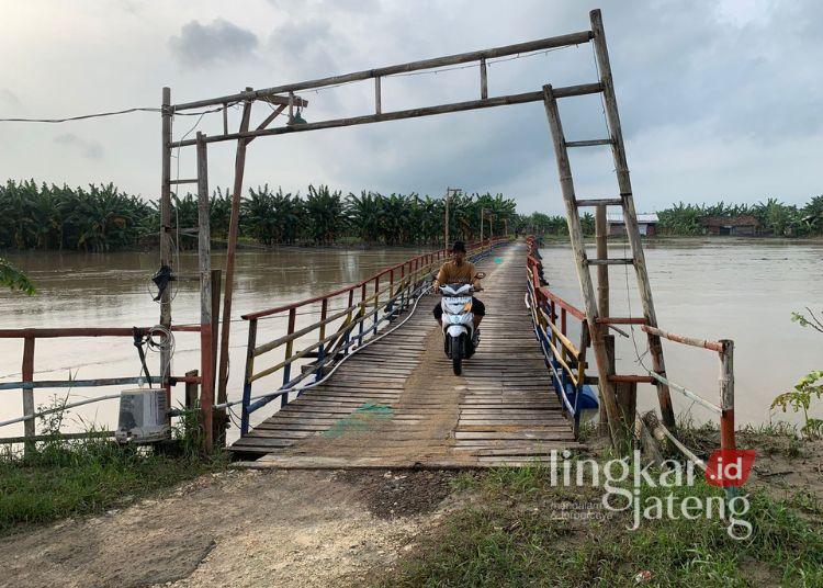Warga saat melintas di Jembatan Apung Sambung Roso, Selasa (28/1). (Lingkar Network | M. Burhanudin Aslam - Lingkarjateng.id)