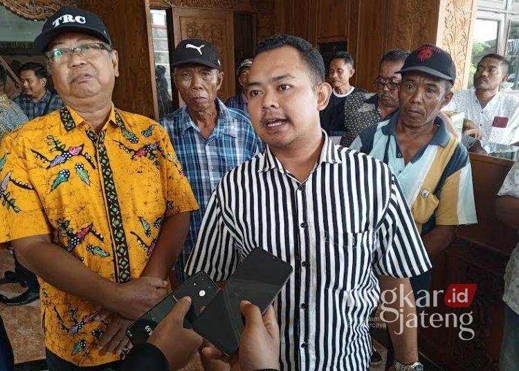 Sejumlah warga Dengkek bersama Anggota Badan Permusyawaratan Desa (BPD), Bayu memperlihatkan berkas hasil audiensi di Depan Kantor DPRD Kabupaten Pati, Jumat, 17 Januari 2025. (Setyo Nugroho/Lingkarjateng.id)