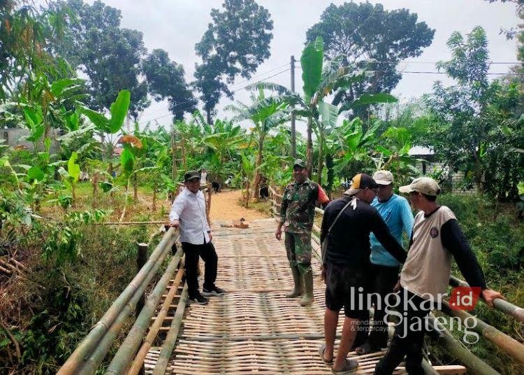 GOTONG ROYONG: Pemerintah Desa Pelemgede, Kecamatan Pucakwangi, Kabupaten Pati bersama anggota TNI-Polri bersama masyarakat bergotong royong membangun jembatan alternatif dengan bumbu, Rabu, 26 Februari 2025. (Lingkarjateng.id)