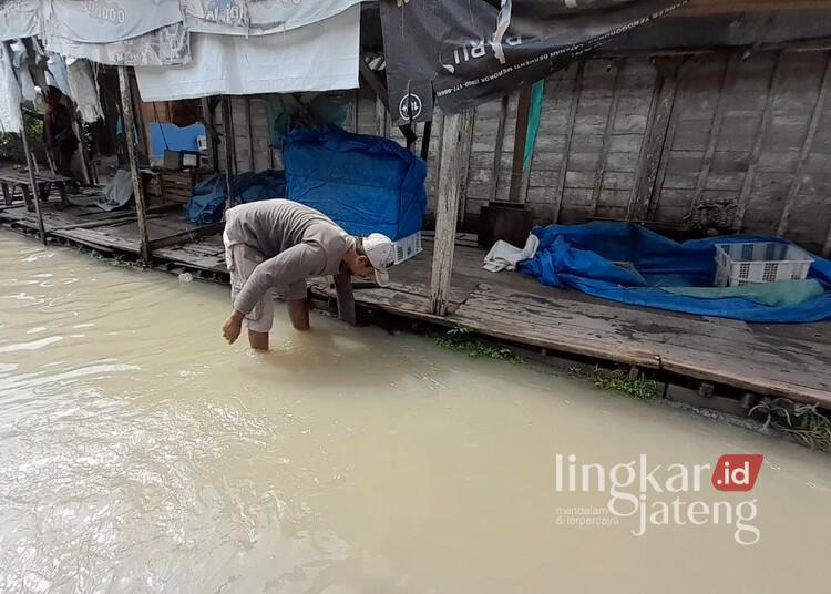 Seorang pedagang saat melihat kondisi banjir yang merendam Pasar Wado, Kecamatan Kedungtuban, Kabupaten Blora, pada Rabu, 26 Februari 2025. (Eko Wicaksono/Lingkarjateng.id)