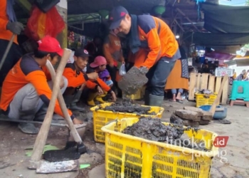 Sejumlah petugas bersama pedagang saat menjebol cor penutup selokan untuk menanggulangi banjir yang sering melanda Pasar Rembang, Selasa, 4 Februari 2025. (Rembangkab/Lingkarjateng.id)