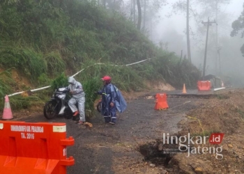 Warga menuntun motornya melewati jalan utama di wilayah Kliweran, Kecamatan Petungkriyono, Kabupaten Pekalongan, yang kembali ambles imbas hujan deras yang mengguyur wilayah setempat, Kamis, 6 Februari 2025. (Fahri Akbar/Lingkarjateng.id)