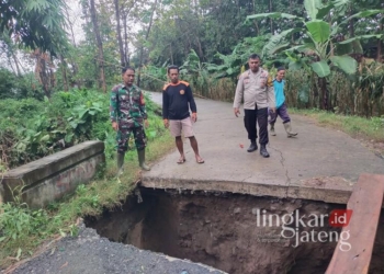 Petugas dan warga saat melihat kondisi jembatan di Dukuh Pidik, Desa Wonosari, Kecamatan Pegandon, Kabupaten Kendal, yang ambrol akibat longsor pada Minggu, 9 Februari 2025. (Dok. Pribadi/Lingkarjateng.id)