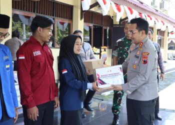 Kapolres Kendal, AKBP Feria Kurniawan, secara simbolis menyerahkan paket sembako kepada perwakilan mahasiswa dalam kegiatan Baksos Presisi yang digelar di Aula Tribrata Polres kendal pada Kamis, 27 Februari 2025. (Dok. Polres Kendal/Lingkarjateng.id)